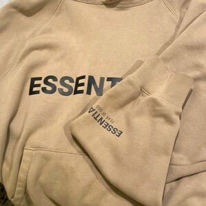 The brand of this hoodie is Fear of God essentials hoodie The color of this tan.